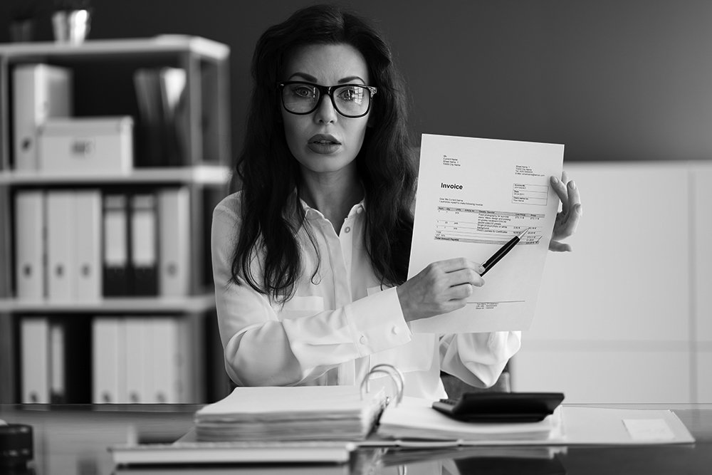 Accountant businesswoman showing late invoice needing client to pay.